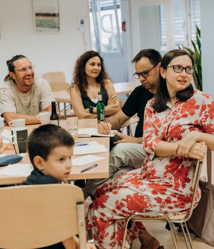 Teilnehmende hören zu und diskutieren beim Quizabend „Eine Minute zum Nachdenken“