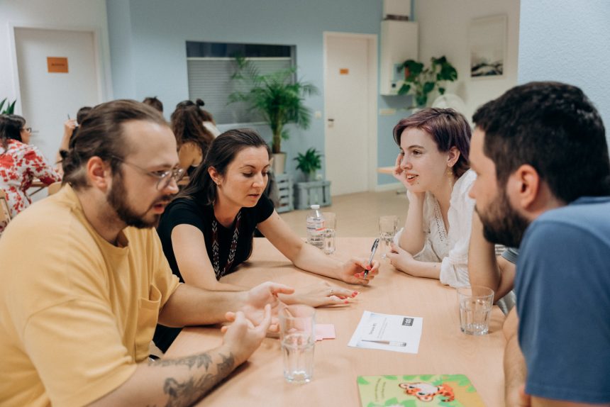 Teilnehmende diskutieren in kleinen Teams beim Quizabend „Eine Minute zum Nachdenken“