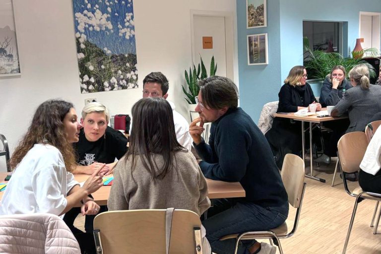 Teams diskutieren konzentriert beim Quizabend „Eine Minute zum Nachdenken“