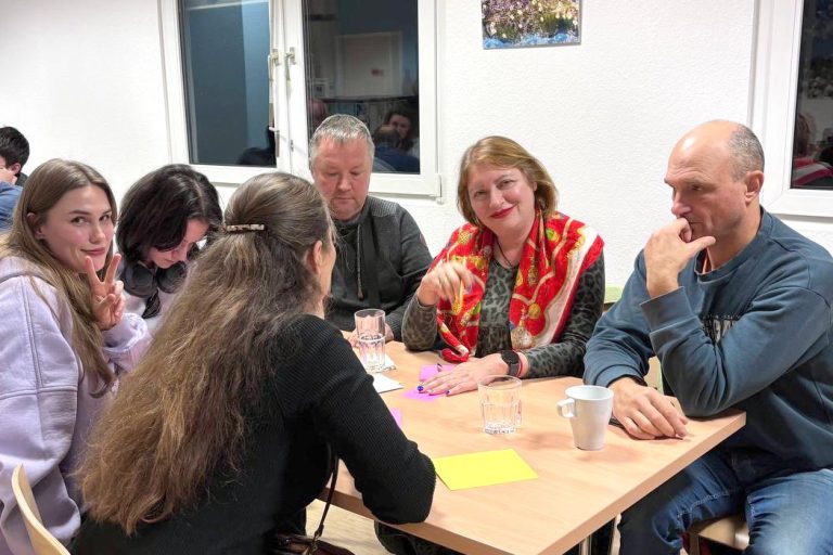 Teilnehmende im Gespräch beim Quizabend „Eine Minute zum Nachdenken“ über die Ukraine